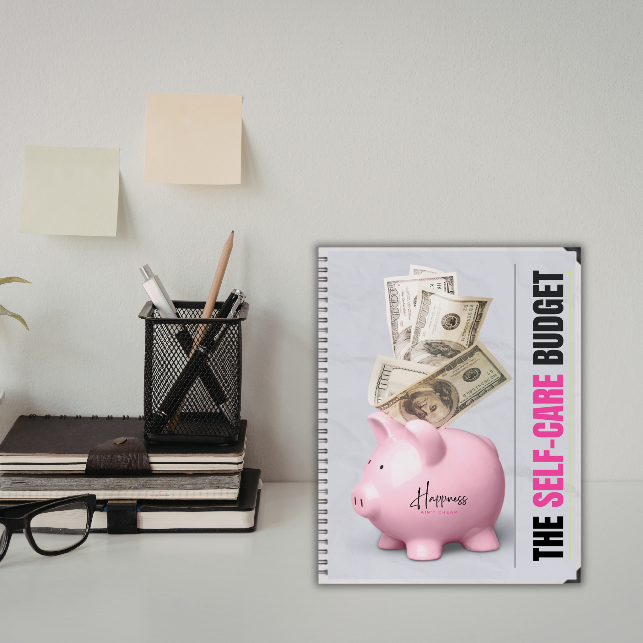 The Self-Care Budget Planner on a desk with desk supplies and stationery